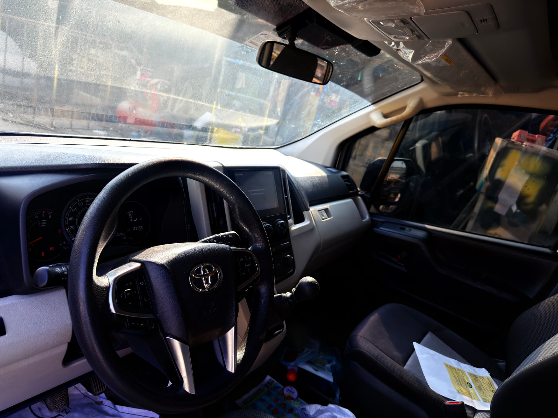 Driver cockpit of Toyota Hiace rental van with touchscreen head unit and dashboard