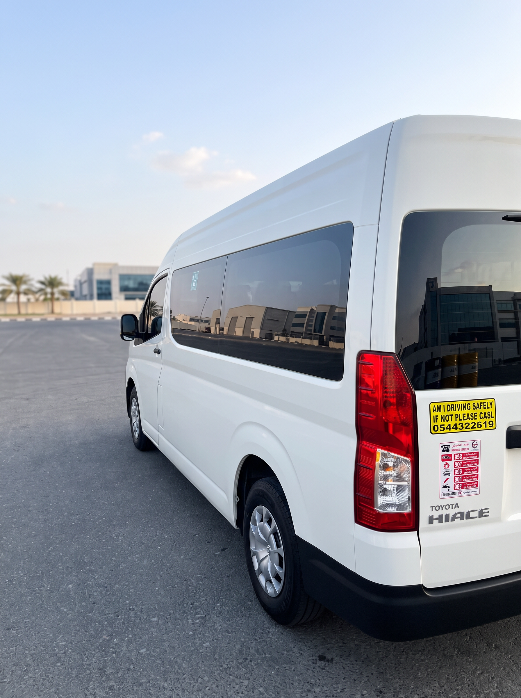 Rear three-quarter view of Toyota Hiace 14-seater van with tinted glazing for airport transfers in Dubai