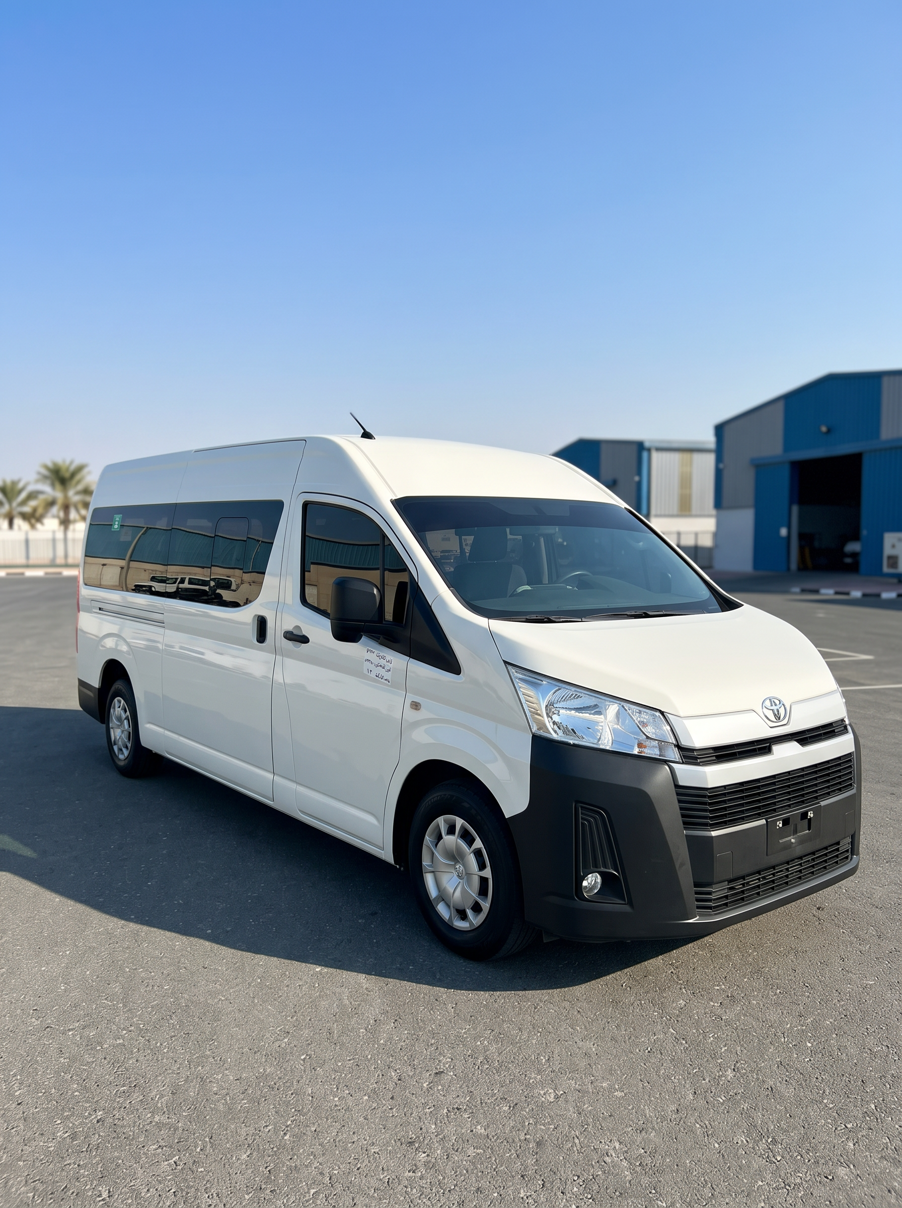 Side profile of Toyota Hiace high-roof 14-seater passenger van with tinted windows, Dubai